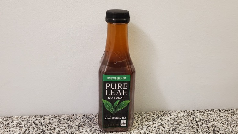 A bottle of Pure Leaf Unsweetened Black Tea on black and grey granite counter