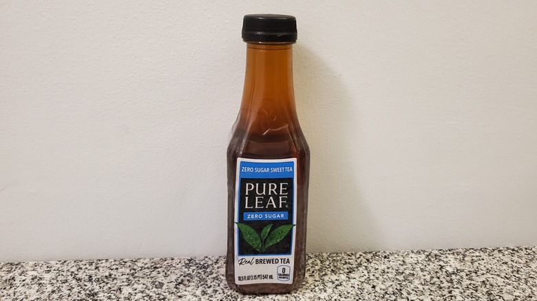 A bottle of Pure Leaf Zero Sugar Sweet Black Tea on black and grey granite counter
