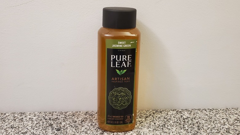 A bottle of Pure Leaf Sweet Jasmine Green Tea on black and grey granite counter