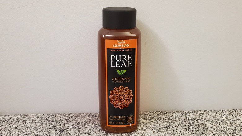 A bottle of Pure Leaf Sweet Assam Black Tea on black and grey granite counter