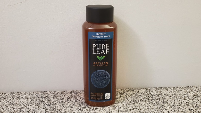A bottle of Pure Leaf Unsweet Darjeeling Black Tea on black and grey granite counter