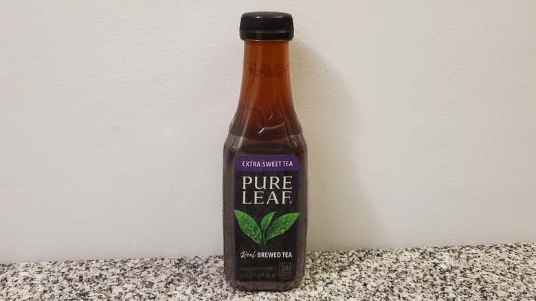 A bottle of Pure Leaf Extra Sweet Black Tea on black and grey granite counter