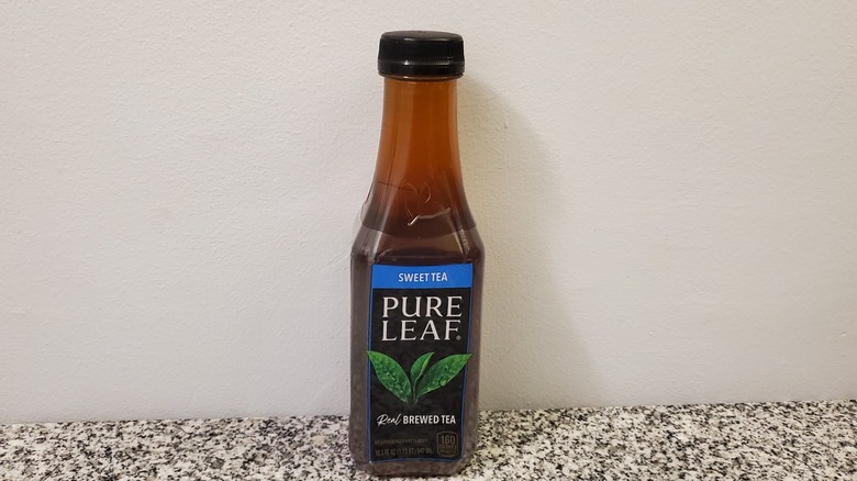 A bottle of Pure Leaf Sweet Black Tea on black and grey granite counter