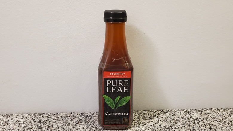 A bottle of Pure Leaf Raspberry Black Tea on black and grey granite counter